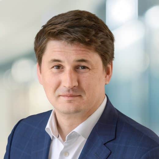 A smiling headshot of Alexander Sannikov, President and Chief Operating Officer of Dream Industrial, against a blurry background