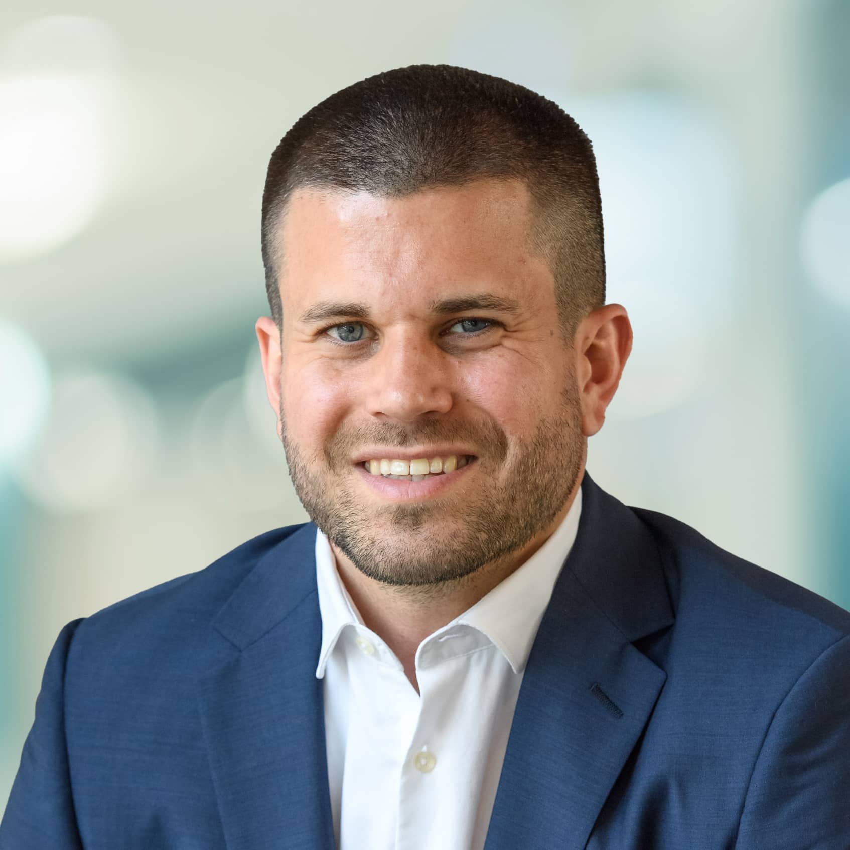 Headshot of Stephen Cleghorn, VP Portfolio Management, wearing a blue blazer and white button up shirt with the first button undone
