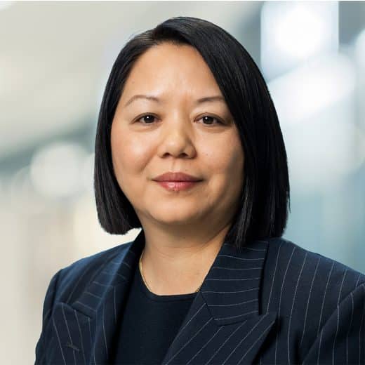 Smiling headshot of Tsering Yangki, EVP, Real Estate Finance & Development, wearing a striped blazer