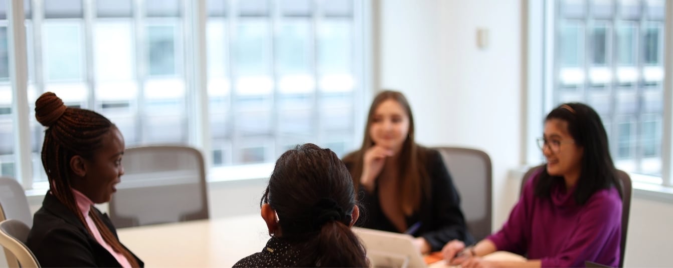 four women in a boardroom having a meeting