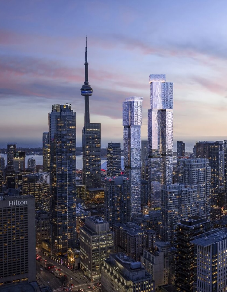 Cityscape at dusk featuring the CN Tower and modern skyscrapers with stacked rectangular designs, illuminated by a blend of natural and artificial light, with the Hilton building visible in the lower-left corner